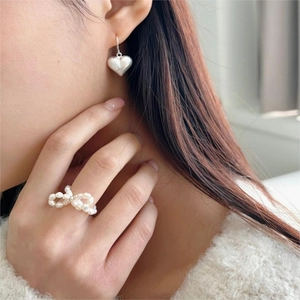 Close-up of S925 sterling silver bow ring with freshwater pearls worn by a model
