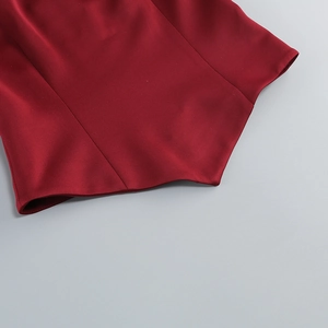 Détail du satin rouge foncé montrant l'ourlet pointu unique et les coutures précises