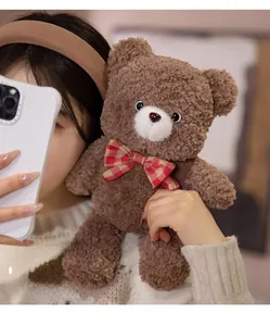Close-up of brown plush teddy bear with a red checkered bow tie and curly lamb wool texture
