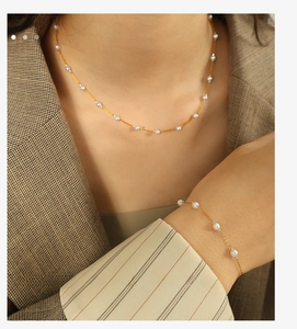 Detail of minimalist gold chain pearl necklace and bracelet set on a model