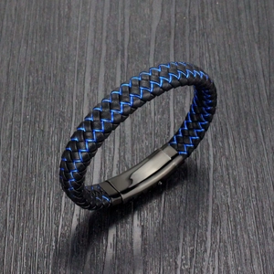 Braided black leather bracelet with blue stitching on a dark wooden texture background