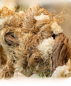 Close-up of natural raffia straw fibers and dried white flowers for bouquet gift packaging