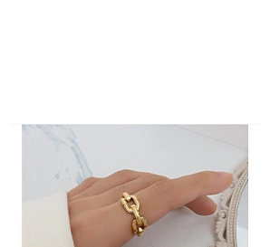 Detail of a minimalist gold-plated irregular oval pendant and chain on marble
