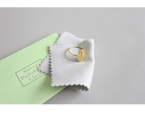 Golden embossed Virgin Mary ring set with a grey polishing cloth and green pouch