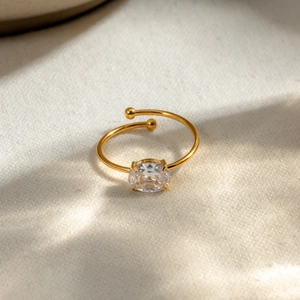Detail view of adjustable 18k gold stainless steel ring with oval clear zircon stone