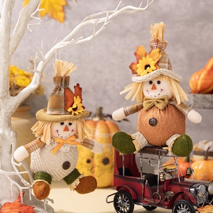 Hanging and sitting harvest scarecrow dolls with autumn leaves and sunflowers decor