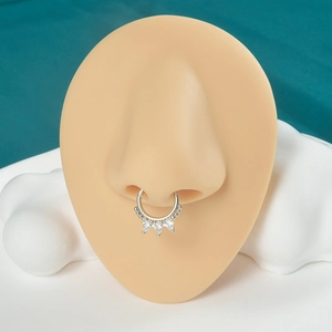 Close-up of a silver crown-shaped septum ring with three sparkling cubic zirconia gems