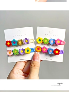 Detailed view of colorful resin five-petal flower hair clips on white display cards