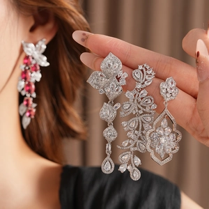 Gros plan de boucles d'oreilles fleurs et feuilles avec pierres de zircone brillantes