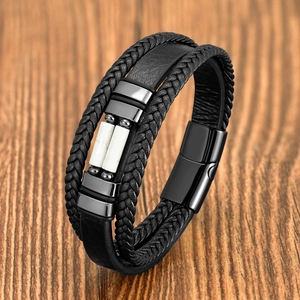 Détail d'un bracelet multicouche en cuir noir avec perles en pierre blanche et fermoir