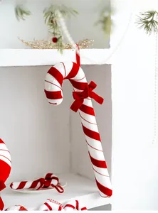 Detail of red and white velvet candy cane ornament with a bow for Christmas tree decoration