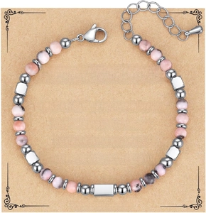 Macro shot of 4mm pink zebra jasper beads and silver charms on a handmade bracelet