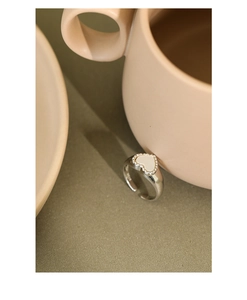 Detail view of S925 sterling silver ring with white heart shell inlay on a saucer