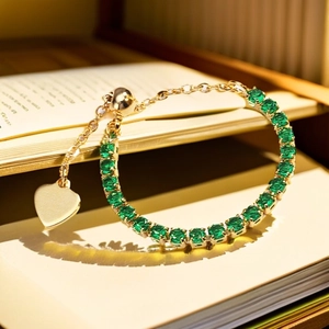 Close-up of a gold chain bracelet with green zircon stones on a vintage book