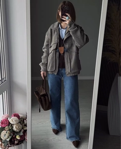 Chic grey herringbone short jacket paired with blue wide-leg jeans and a brown handbag