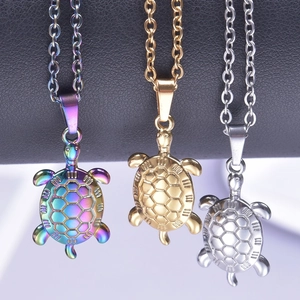 Three turtle pendants in gold, silver, and iridescent steel on matching metal chains