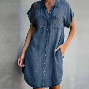Detail of a dark denim shirt dress showing functional side pockets and button closure