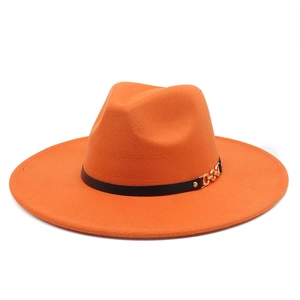 Detail of orange wool fedora hat featuring a black band with a gold metal chain buckle