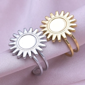 Macro shot of sunburst geometric rings in gold and silver finish on soft silk
