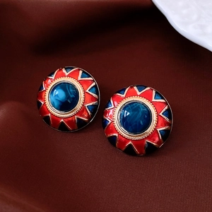 Macro detail of vintage round resin stud earrings with red and blue enamel finish