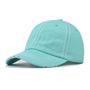 Detail of mint green washed cotton baseball hat with contrast stitching and distressed brim