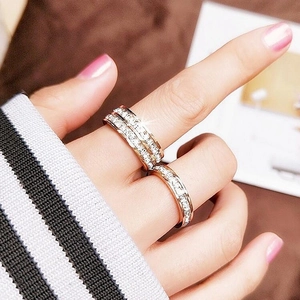 Detailed view of rose gold titanium steel rings with cubic zirconia crystals worn on hand