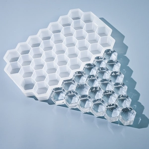 Vue détaillée du bac à glaçons alvéolé en silicone à 37 cases avec glaçons hexagonaux et fond bleu