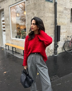 Outdoor street shot of a red cable-knit sweater paired with grey plaid high-waisted trousers