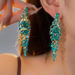 Luxurious green rhinestone water drop tassel earrings shown on a model with a warm glow