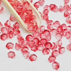 Macro detail of red gradient lily of the valley glass beads for DIY jewelry making