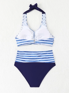 Vista piatta di un bikini a righe con scollo all'americana e fiocco blu su pelliccia bianca
