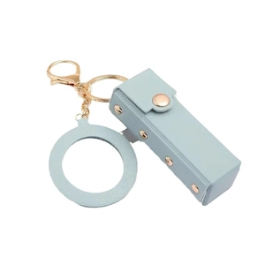 Light blue leather lipstick pouch keychain with gold clasp and rivets on white background