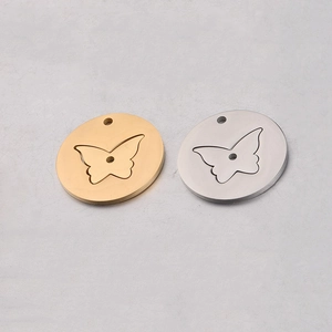 Detail of round gold and silver stainless steel pendants with butterfly hollow design