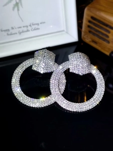 Detailed view of silver hoop earrings featuring sparkling rhinestones and a luxury finish