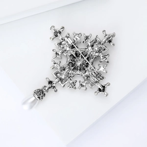 Detail of silver vintage baroque cross brooch with pearl pendant and secure back pin