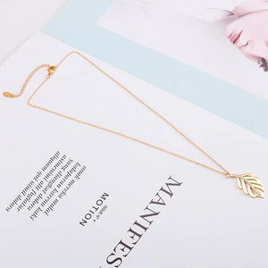 Détail du pendentif feuille dorée avec cristaux et poinçon S925 sur collier minimaliste