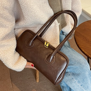 Minimalist vintage dark brown leather shoulder bag shown with model in casual outfit