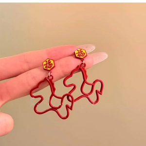 Detailed shot of red enamel Fu character earrings with horse-shaped metal pendants