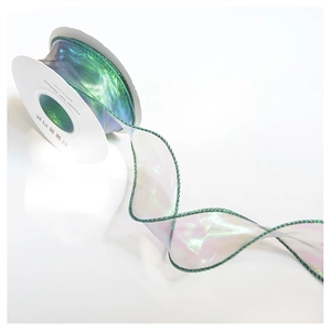 Close-up of iridescent organza gift ribbon with dark green edges in elegant S-curve style