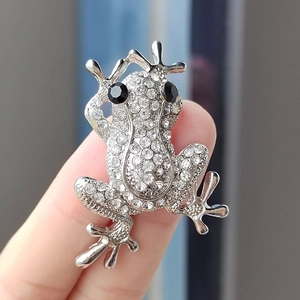Macro detail of frog brooch featuring sparkling white rhinestones and black gem eyes