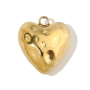 Detailed macro view of heart-shaped gold titanium steel pendant with hammered texture surface