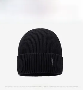 Close-up of black ribbed knit beanie featuring a small vertical NY & JA textile label
