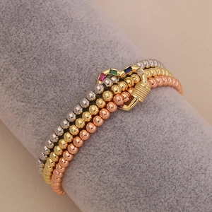 Three-piece set of beaded bracelets in gold, silver, and rose gold with heart stone clasps