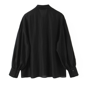 Blusa negra de mujer con mangas de farol, puños abotonados y tejido semitransparente