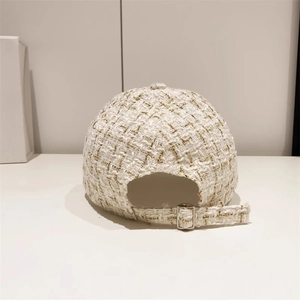 Detailed back view of tweed baseball cap showing adjustable strap and silver metal buckle