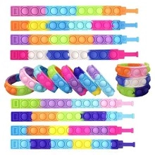 Detail of colorful silicone pop-it wristbands in rainbow and gradient tie-dye patterns