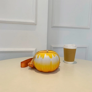 Detail view of round yellow gradient pumpkin crossbody bag with bright wide strap and zipper
