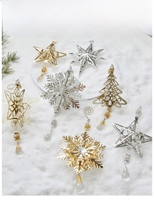 Detailed view of hollow iron Christmas ornaments with crystal pendants on faux snow