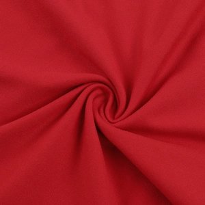 Détail de la texture du tissu en maille rouge montrant un drapé élégant
