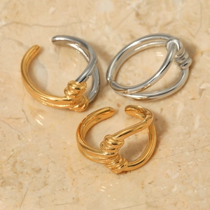 Minimalist knot design open rings in gold and silver finish on marble surface
